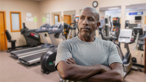 Fit African American man with Pacific Rehabilitation Centers therapy gym in background